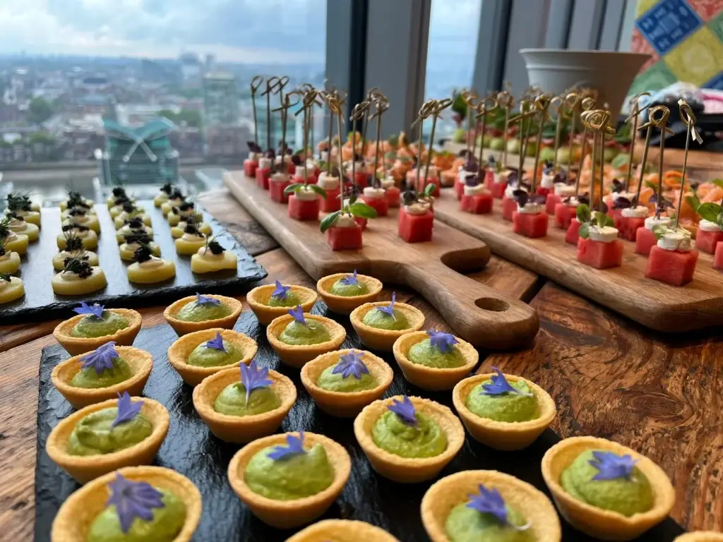 Canapés displayed on serving boards beside a window overlooking the city.